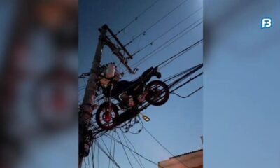 Motocicleta fica presa em fiação elétrica após queda de valão